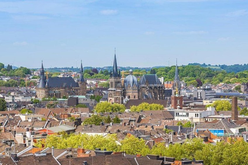 A cityscape with historic buildings, including a church with a prominent dome and spires, surrounded by residential areas and greenery. 3