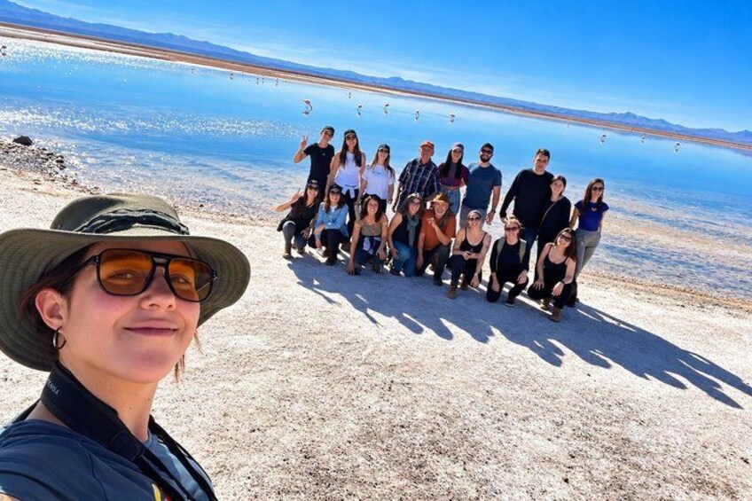 Un grupo de personas en una playa con cielo despejado y un mar tranquilo al fondo. 4