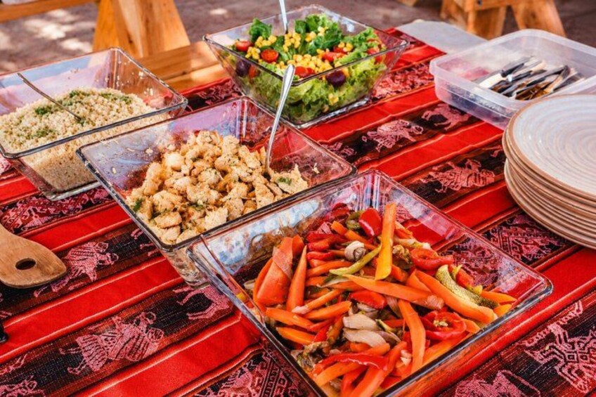 Una mesa de buffet con diferentes alimentos en recipientes de vidrio. 2