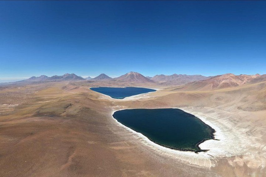 A vast desert landscape with two large lakes and distant mountains. 1