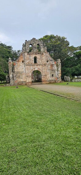 Una antigua estructura de piedra con aberturas en arco y un primer plano cubierto de hierba. 4