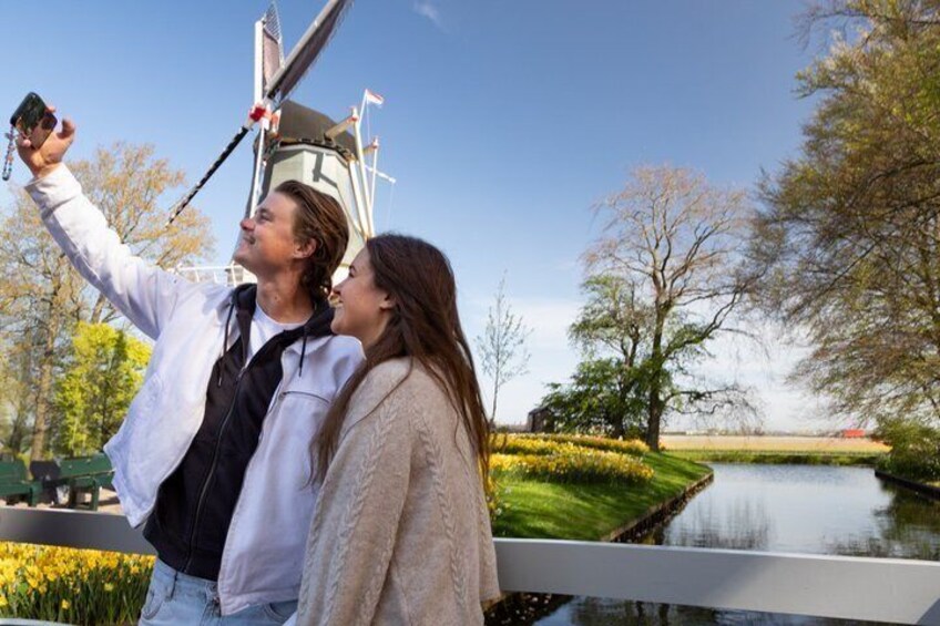 A couple taking a selfie with a bridge and a river in the background. 5