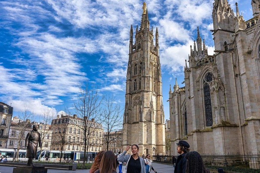 A historic cathedral with tall spires and a statue in the foreground. 5