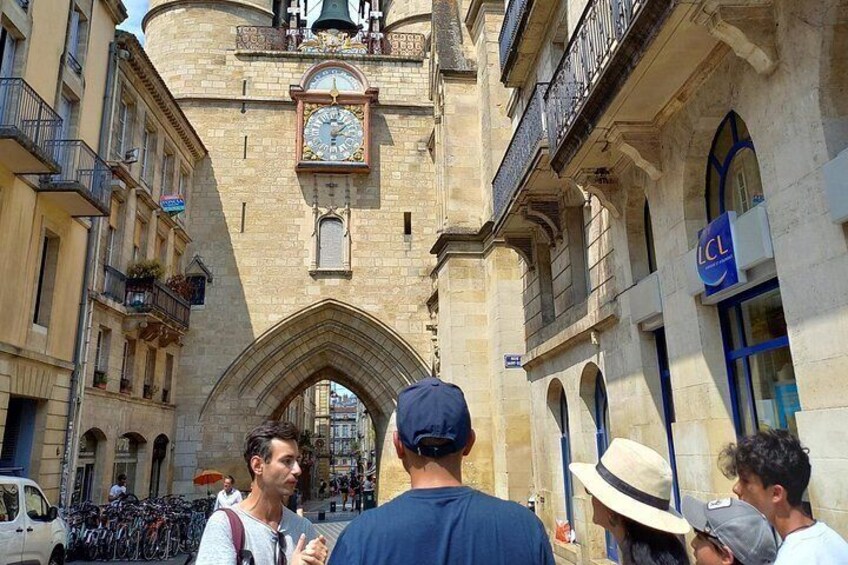 A historic building with a clock tower, a street with bicycles, and pedestrians. 3