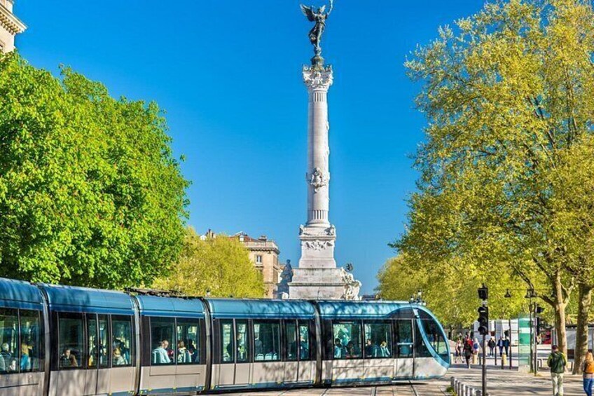 A tram, a tall monument, and green trees. 5