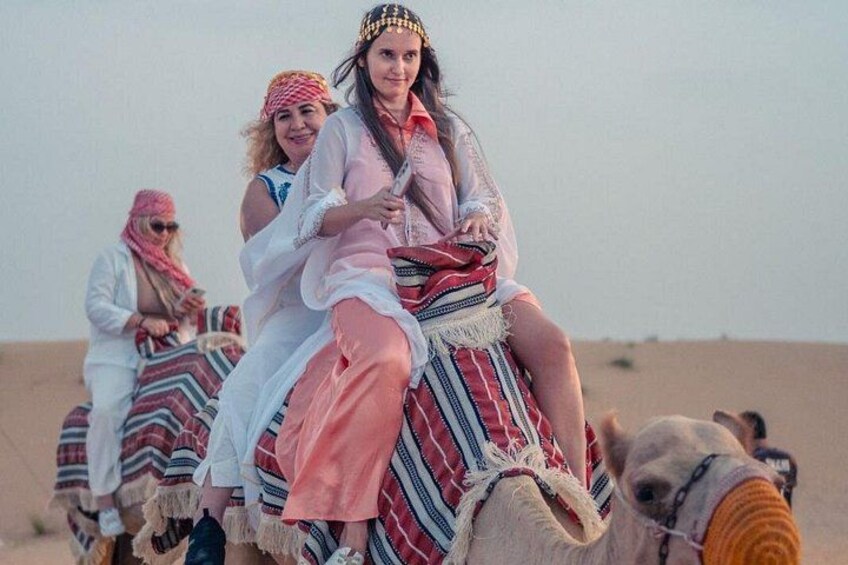 Personas montando camellos en un desierto. 1
