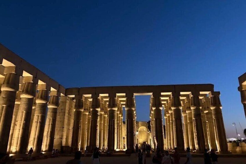 A large, illuminated ancient Egyptian temple with tall columns and a central doorway. 3