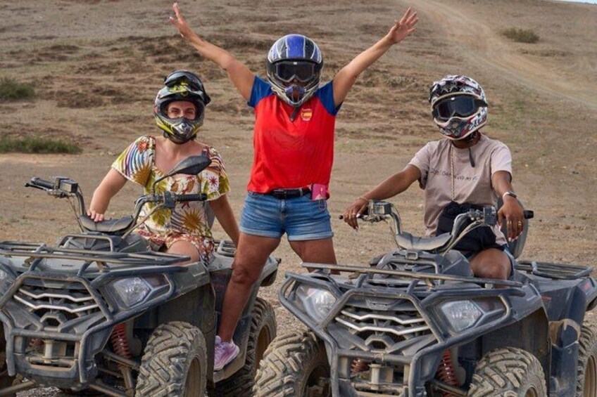 Three people on ATVs on a dirt road. 1