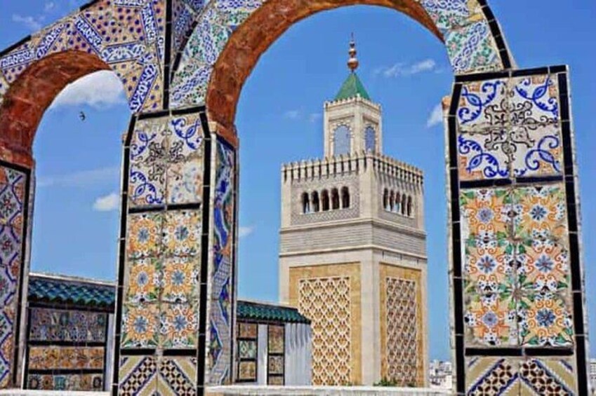 A mosque with a minaret, surrounded by intricately patterned arches. 1