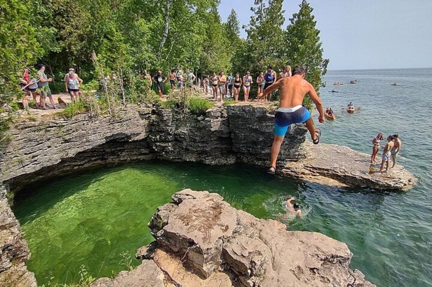 A natural swimming area with a rocky pool surrounded by trees. 1