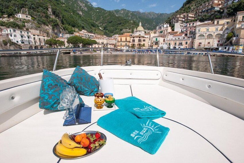 Een boot met een tafel, daarop fruit, een fles en een blauwe handdoek. 4