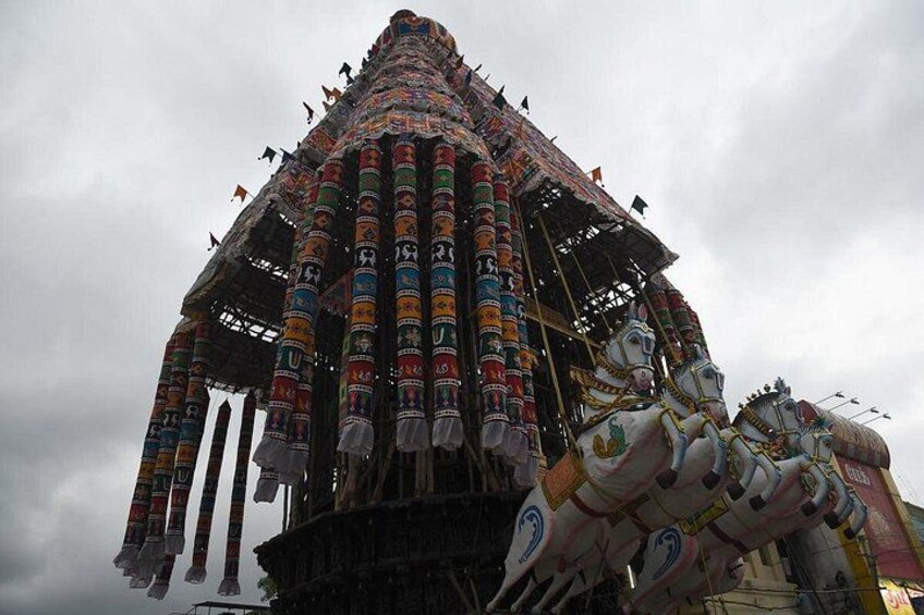 A colorful, intricately decorated temple with a tiered roof and a large statue of a horse. 4