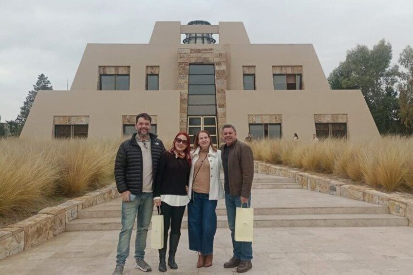 Un gruppo di persone davanti a un edificio moderno con un design architettonico distintivo. 3