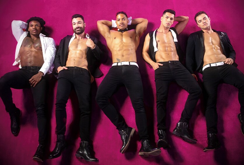 Five men posing against a pink background. 4