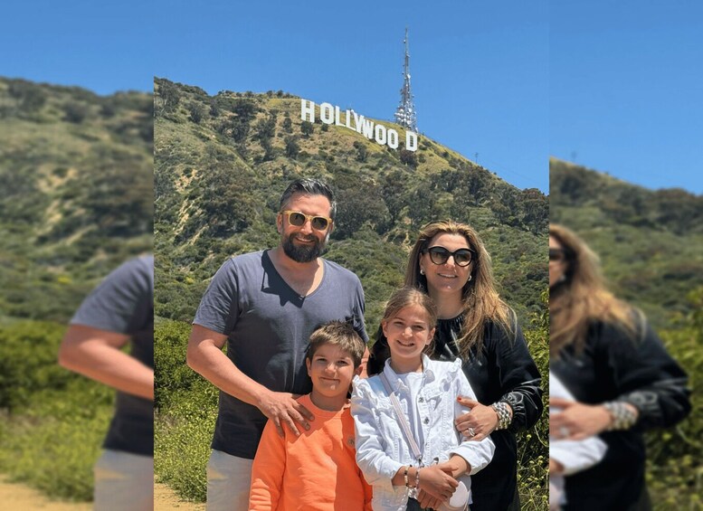 Eine Familie vor dem Hollywood-Schild mit einer bergigen Kulisse. 2
