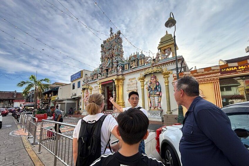 Un temple avec une statue, une rue et une voiture. 2