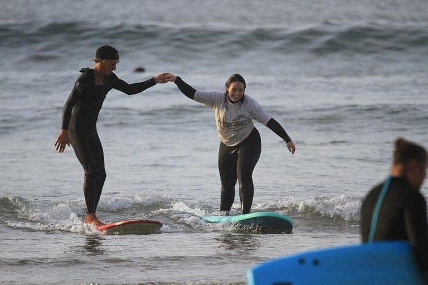 Two people surfing on a calm ocean with waves. 5