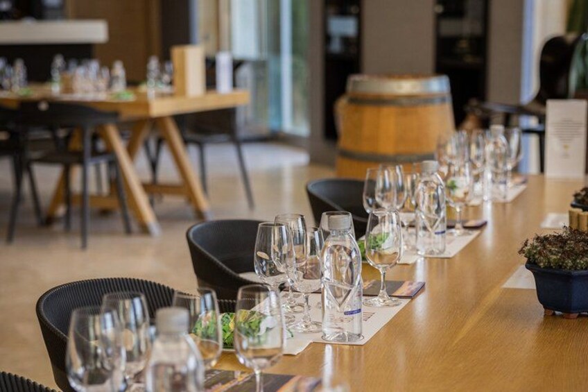 A restaurant setting with tables set for dining, chairs, and a wooden barrel in the background. 3