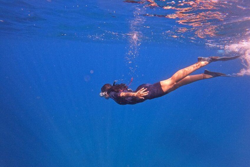 A person swimming underwater. 1
