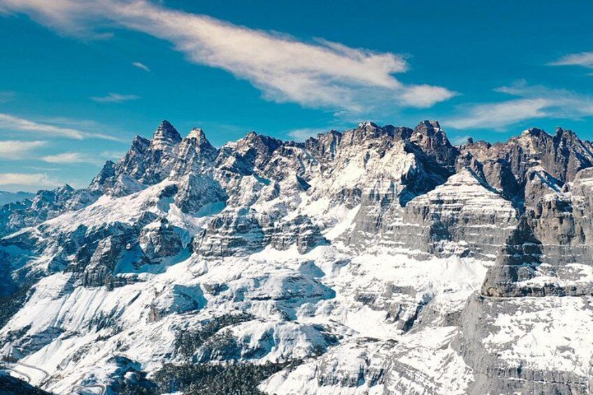 A snow-covered mountain range with sharp peaks and clear blue sky. 5