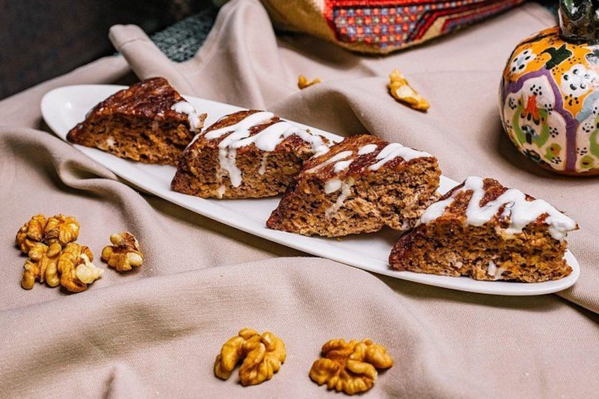 A plate of sliced cake with walnuts and a decorative pumpkin. 4