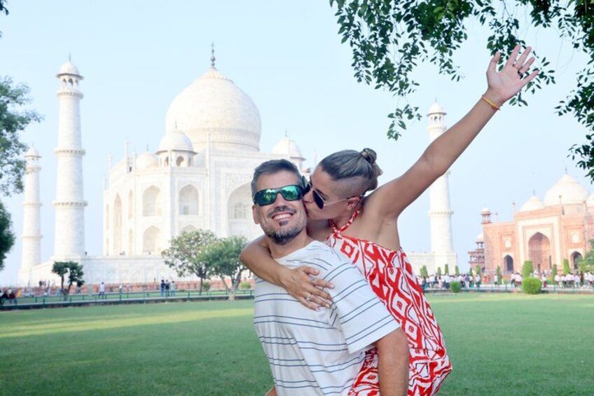 Ein Paar umarmt vor dem Taj Mahal, mit Kuppeln und Minaretten im Hintergrund. 1