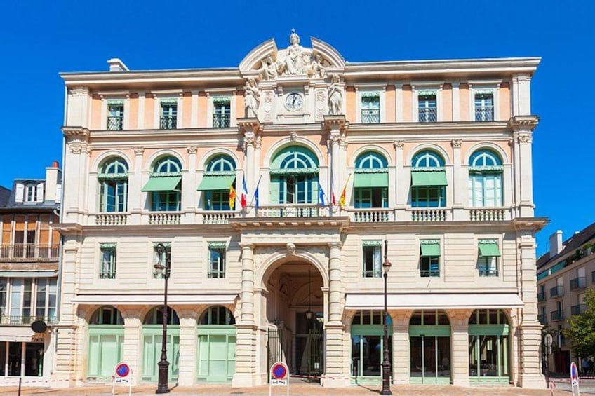 Un bâtiment historique doté d’une arche centrale, de nombreuses fenêtres et de drapeaux. 5