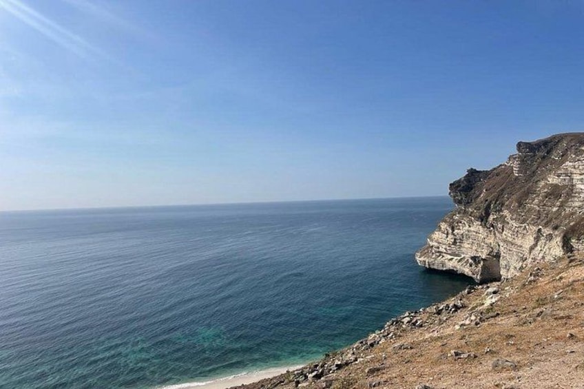 A coastal landscape with cliffs and a clear blue sea. 3