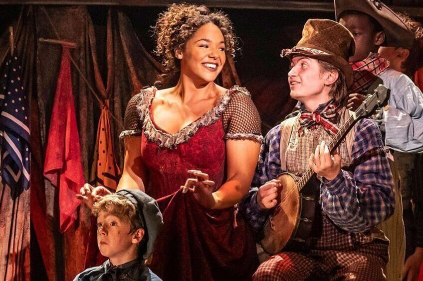 Una función teatral con actores vestidos con trajes de época, una guitarra y un niño disfrazado. 5