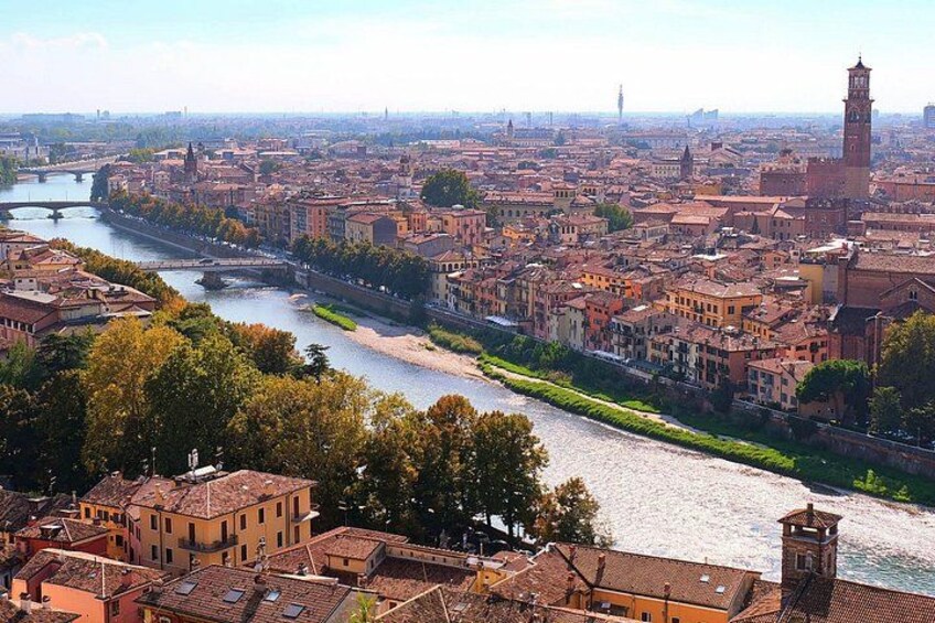 A river winding through a densely built city with historic buildings and a prominent clock tower. 4