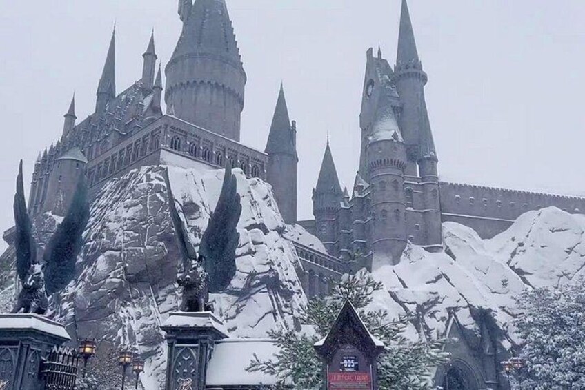 A snow-covered castle with multiple spires and a large rock formation in the foreground. 5