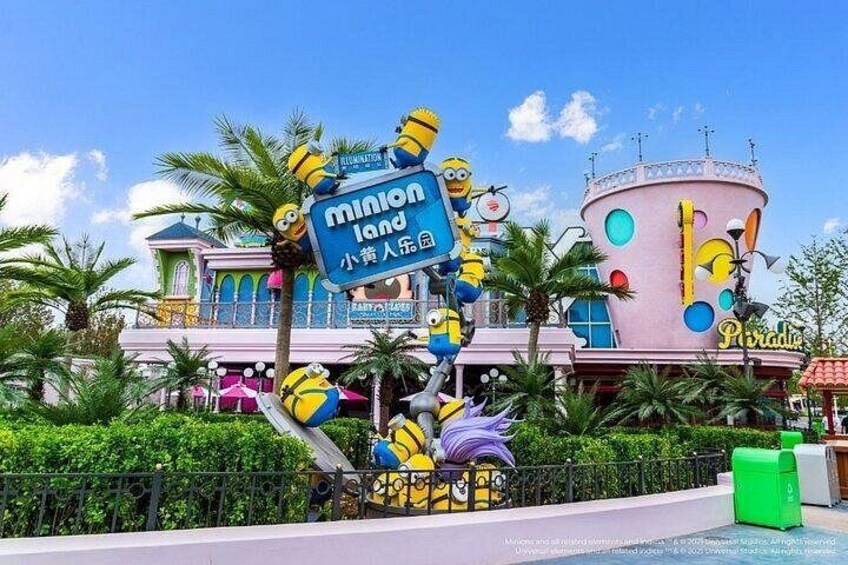 A theme park with a Minion-themed attraction, including a large sign and statues. 4
