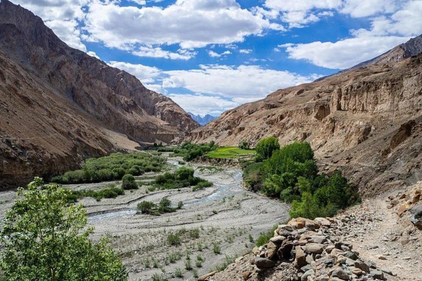 A river winding through a mountainous valley with rocky terrain and sparse vegetation. 1