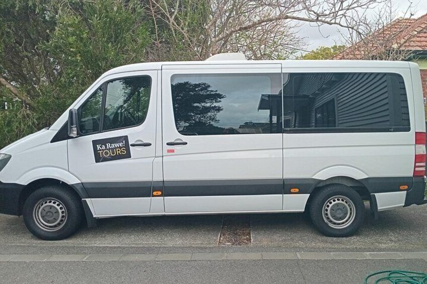 A white van with 'Ka Rawai Tours' written on the side parked on a street. 2