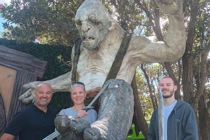 A large statue of a gorilla holding a sign, with three people standing in front of it. 5