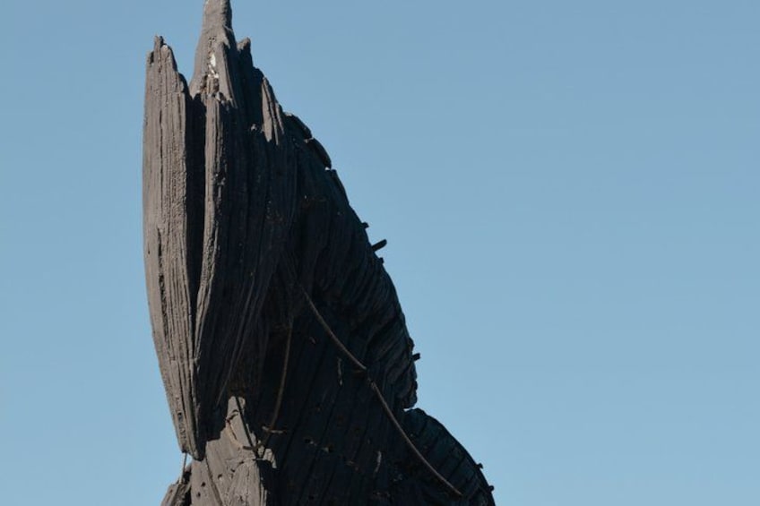 Formación rocosa alta y erosionada, con textura rugosa y bordes irregulares, sobre un cielo azul despejado. 2