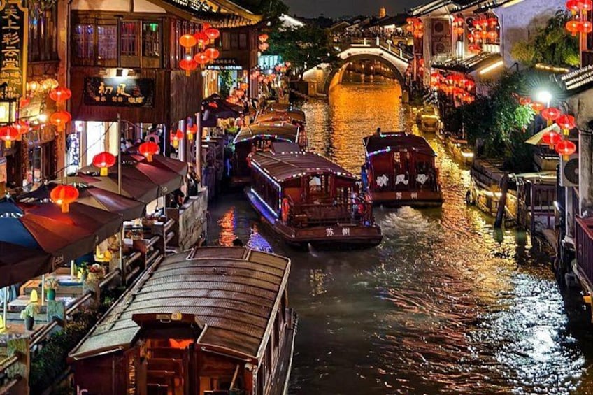 A river with boats, traditional wooden buildings, and red lanterns. 1