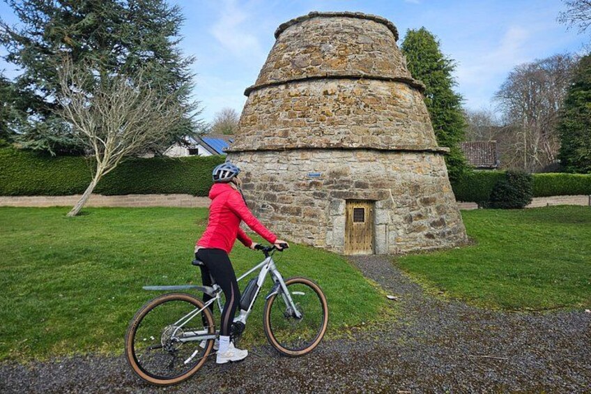 Ein Radfahrer in einer roten Jacke fährt ein Fahrrad in der Nähe eines Steinturms. 4