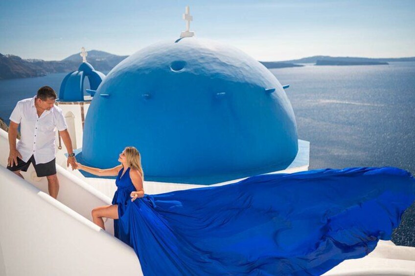 A couple on a boat with a blue-domed building in the background. 3