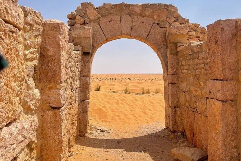 An ancient stone archway leading into a desert landscape. 2