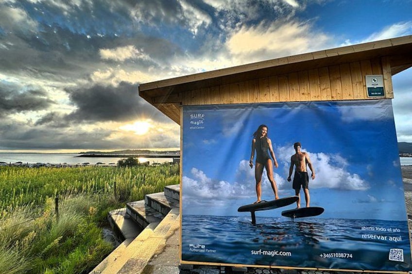 Une structure en bois ornée d’une affiche représentant deux personnes en train de faire de la planche à voile. 2
