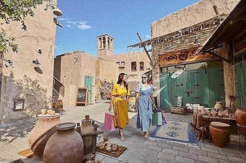 Una calle con cerámica, una tienda con toldo verde y un edificio con un reloj. 2