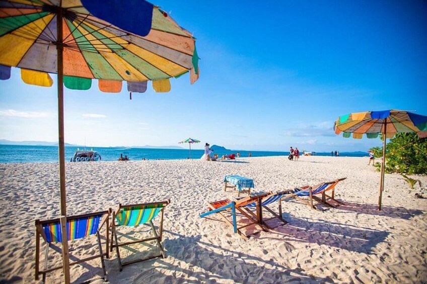 A beach with colorful umbrellas, beach chairs, and a clear blue sky. 4
