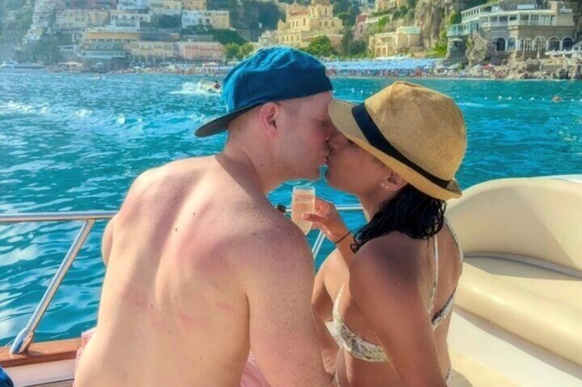 A couple on a boat with a coastal town in the background. 5