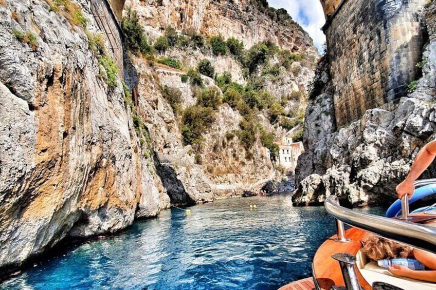 A boat navigating a narrow, rocky waterway surrounded by steep cliffs. 4
