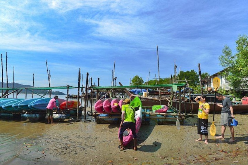A beach with people and colorful kayaks. 2