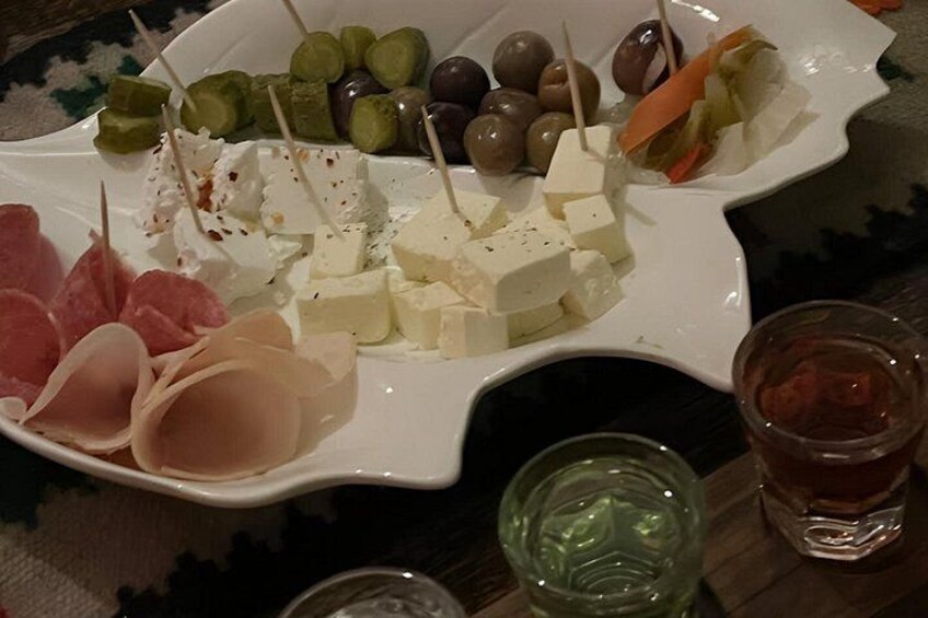 A plate of assorted cheeses, olives, and cured meats. 3