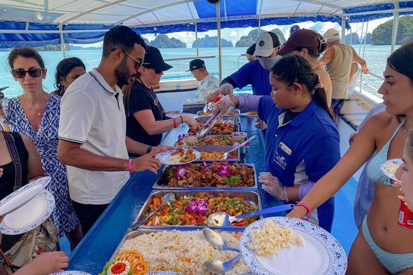 A buffet setup on a boat with various food items and people serving and eating. 3