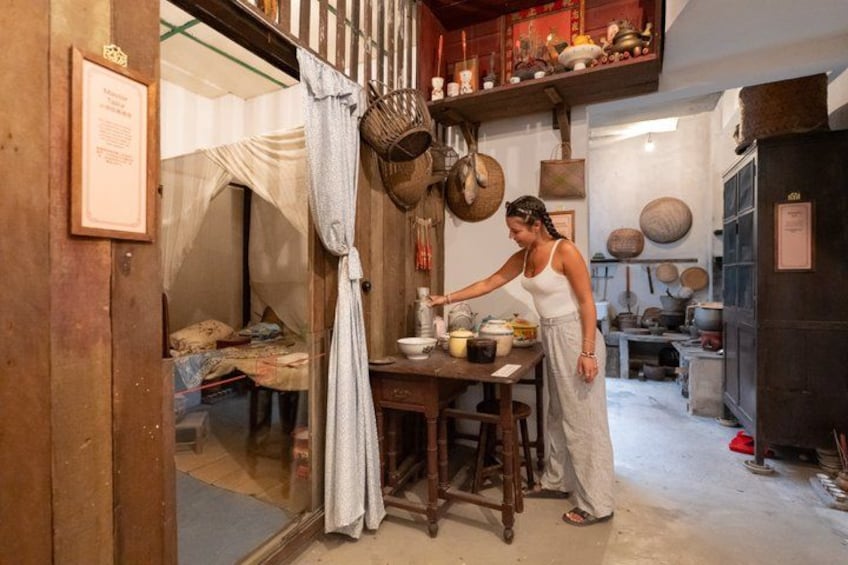 Una persona cocinando en una cocina rústica con muebles de madera, ollas colgantes y utensilios de cocina tradicionales. 1