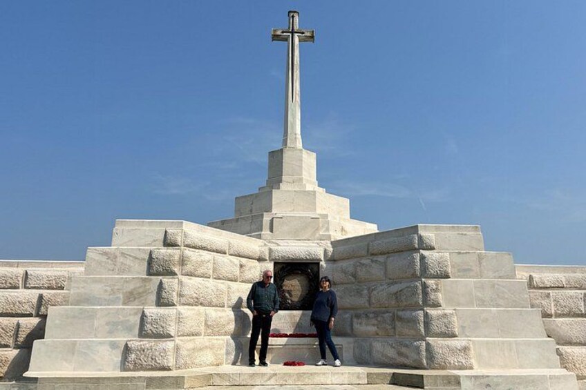 A large stone cross monument with steps leading up to it, surrounded by a clear blue sky. 4
